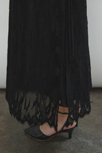 Editorial portrait of a model in the black French lace Kamperett Thea Lace Sheath Dress.