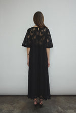 Side view of the black French lace Kamperett Thea Lace Sheath Dress showing the side-tie seams.