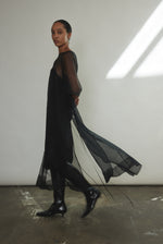 Side view of the black silk organza Kamperett Thea Sheath Dress showing the wide hem facing.