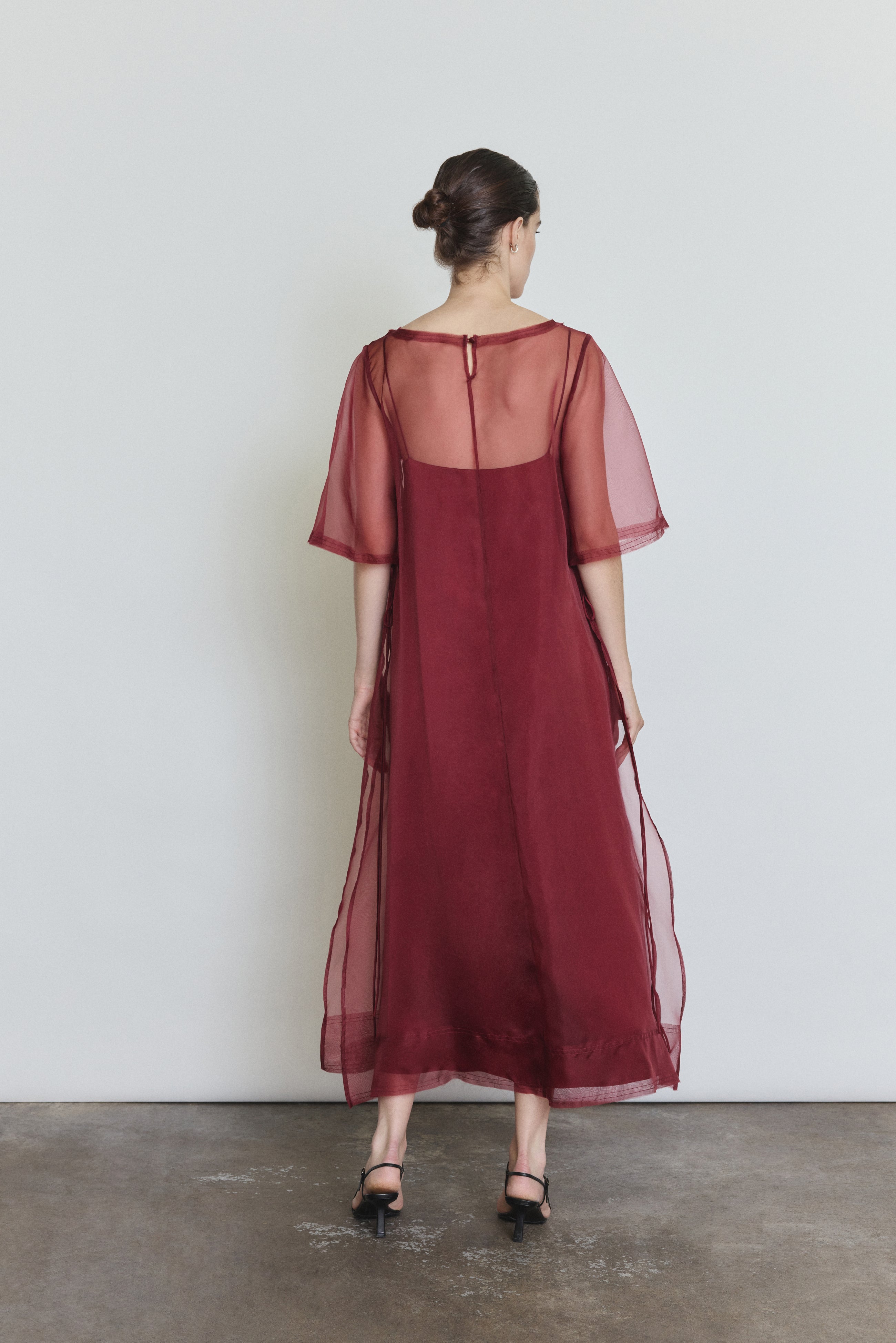 Back view of the bordeaux silk organza Kamperett Thea Sheath Dress showing the straight-cut silhouette.