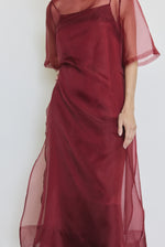 Detail of the bordeaux silk organza Kamperett Thea Sheath Dress showing the raw-edge finishing and side ties.