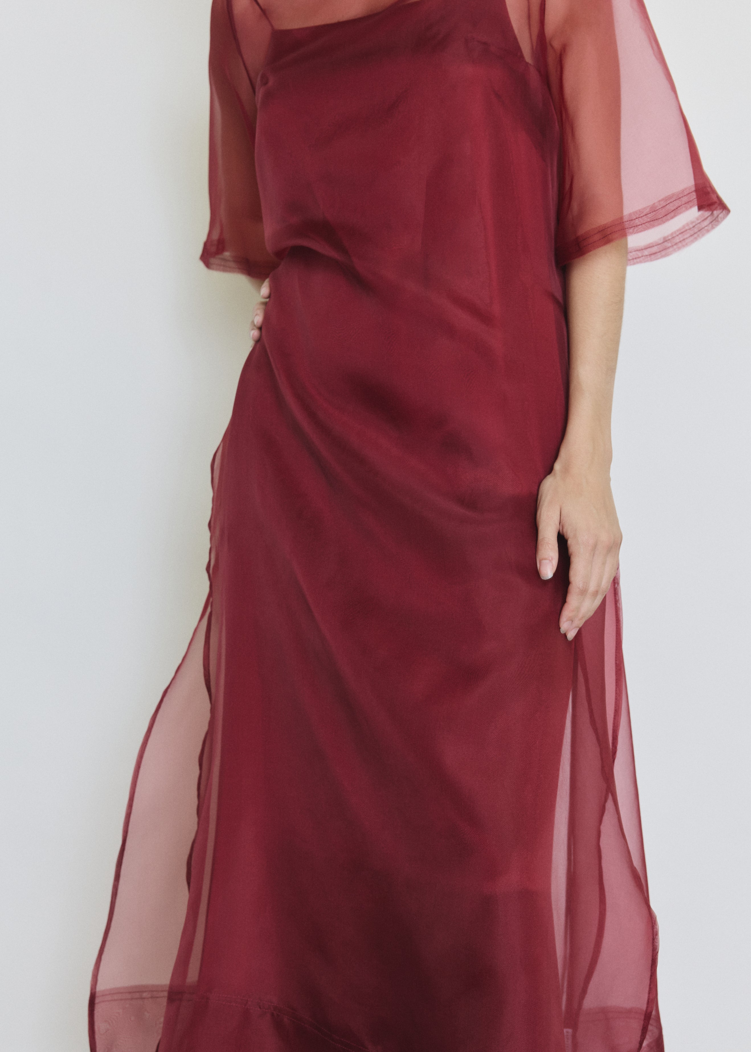 Detail of the bordeaux silk organza Kamperett Thea Sheath Dress showing the raw-edge finishing and side ties.