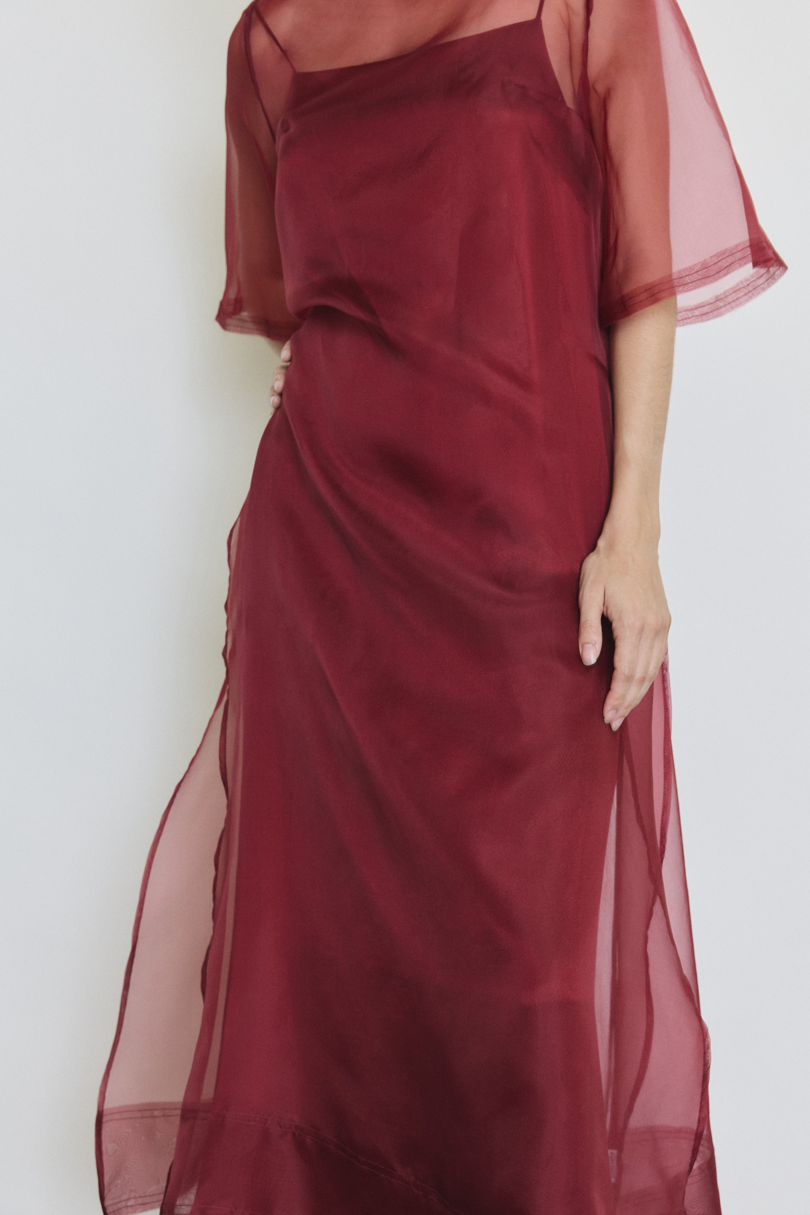 Detail of the bordeaux silk organza Kamperett Thea Sheath Dress showing the raw-edge finishing and side ties.