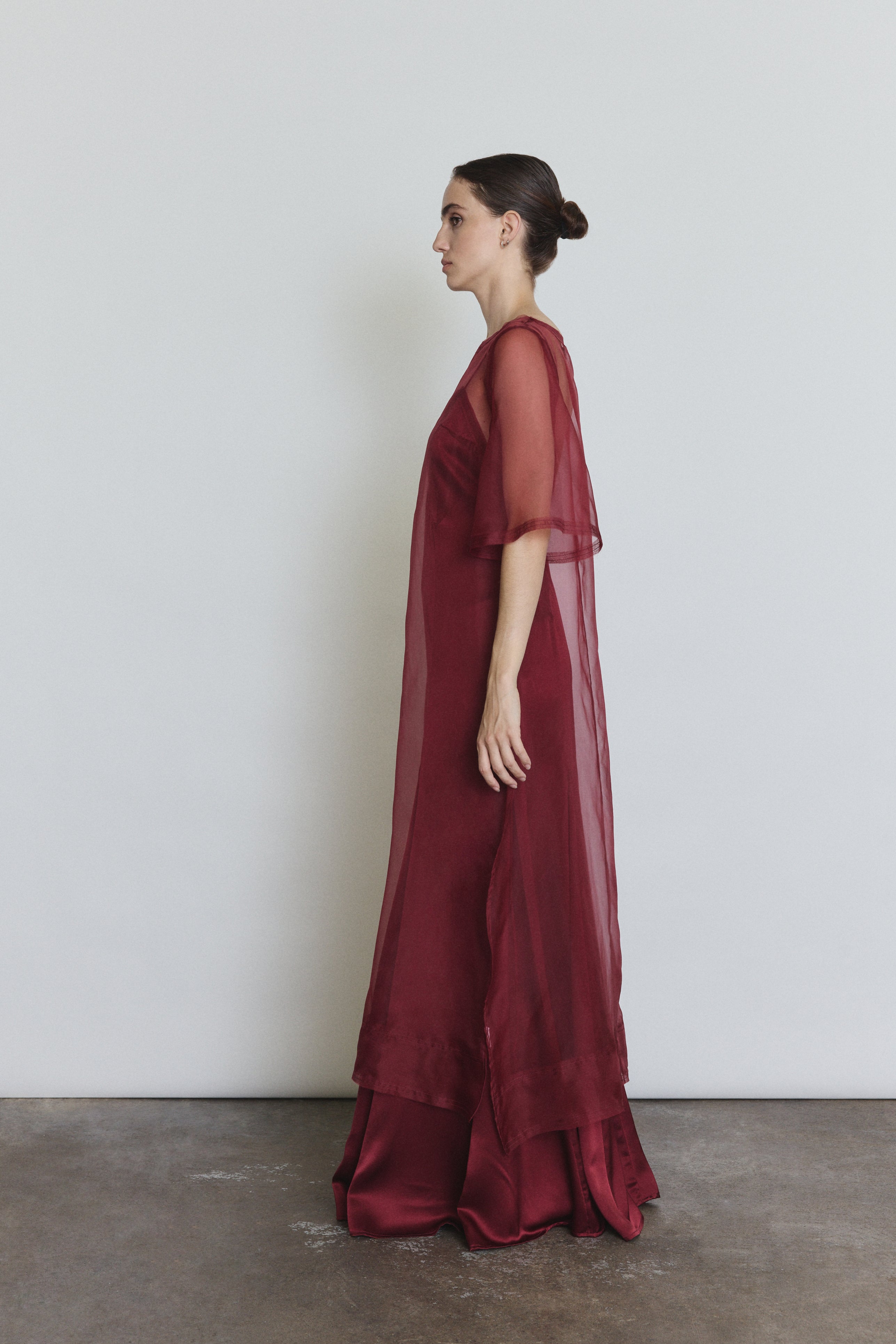 Model wearing the bordeaux Kamperett Thea Sheath Dress layered over the Simone Slip Dress in Bordeaux.