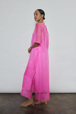 Left profile of hot pink silk organza Thea Sheath Dress. Straight-cut minimalist silhouette glows in saturated silk. Elevated luxury occasion wear, designed in San Francisco.