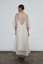 Rear view of ivory silk organza Thea Sheath Dress showing open side seams and wide hem facing. Clean architectural lines, ethically made in California.