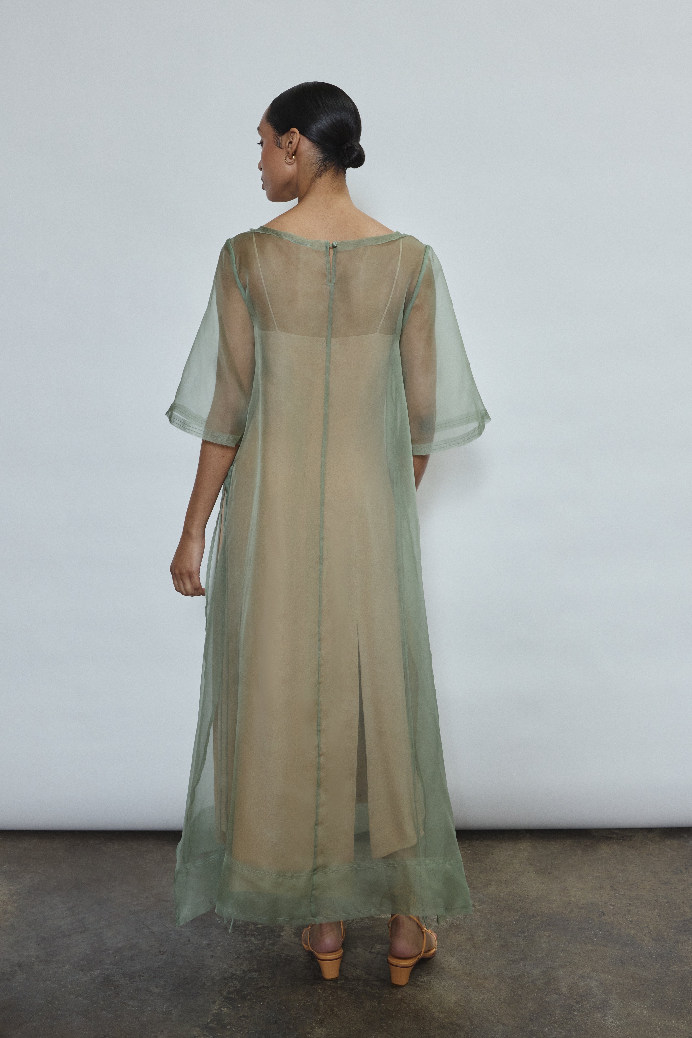 Rear view of jade Thea Sheath Dress in sheer silk organza. Open side seams and wide hem facing show refined construction. Ethically made in California for the discerning woman.
