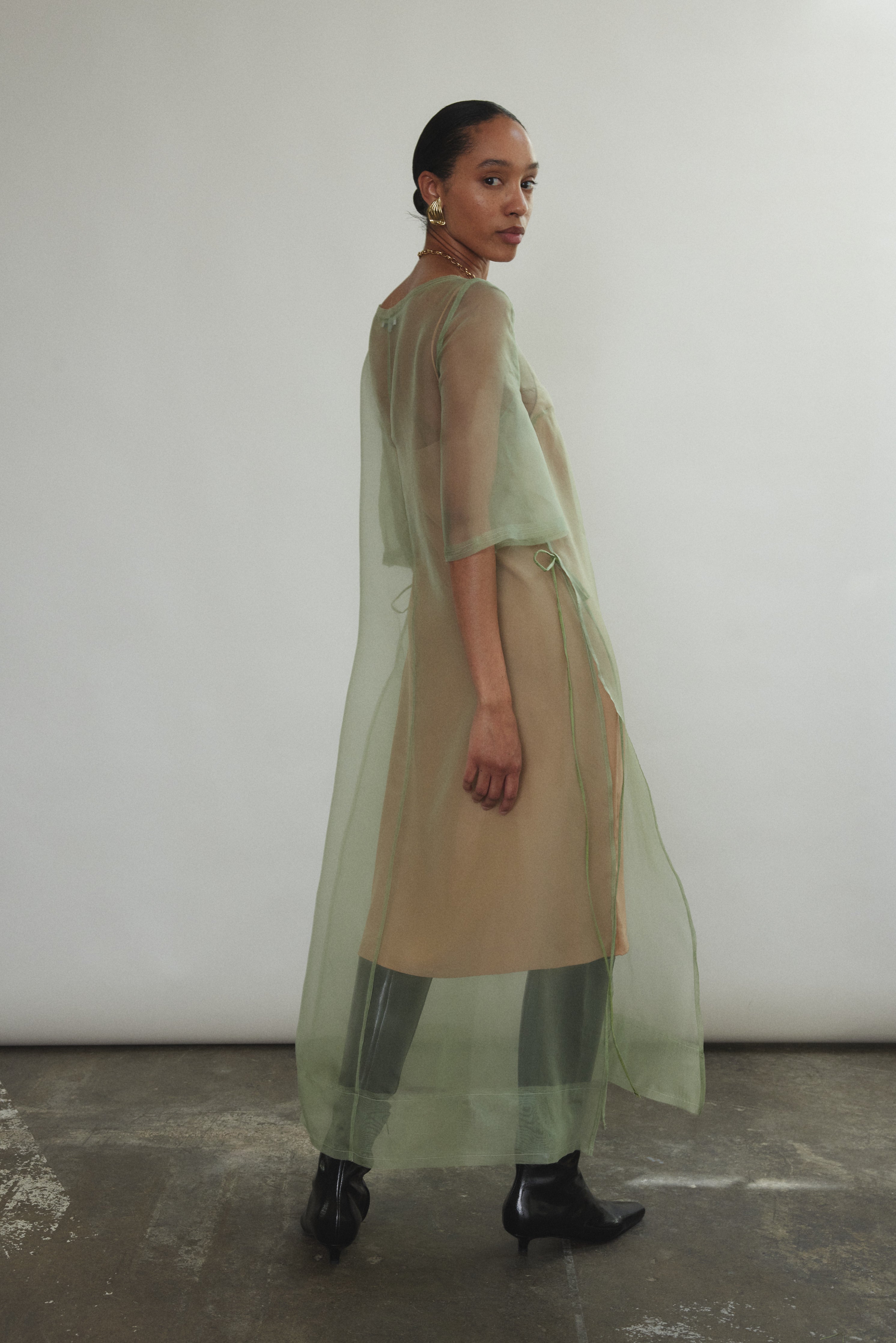 Rear view of jade Thea Sheath Dress in sheer silk organza. Open side seams and wide hem facing show refined construction. Ethically made in California for the discerning woman.