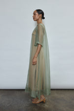 Left profile of jade silk organza Thea Sheath Dress. Straight-cut minimalist silhouette, cool to the touch and luminous in motion. Designed in San Francisco.
