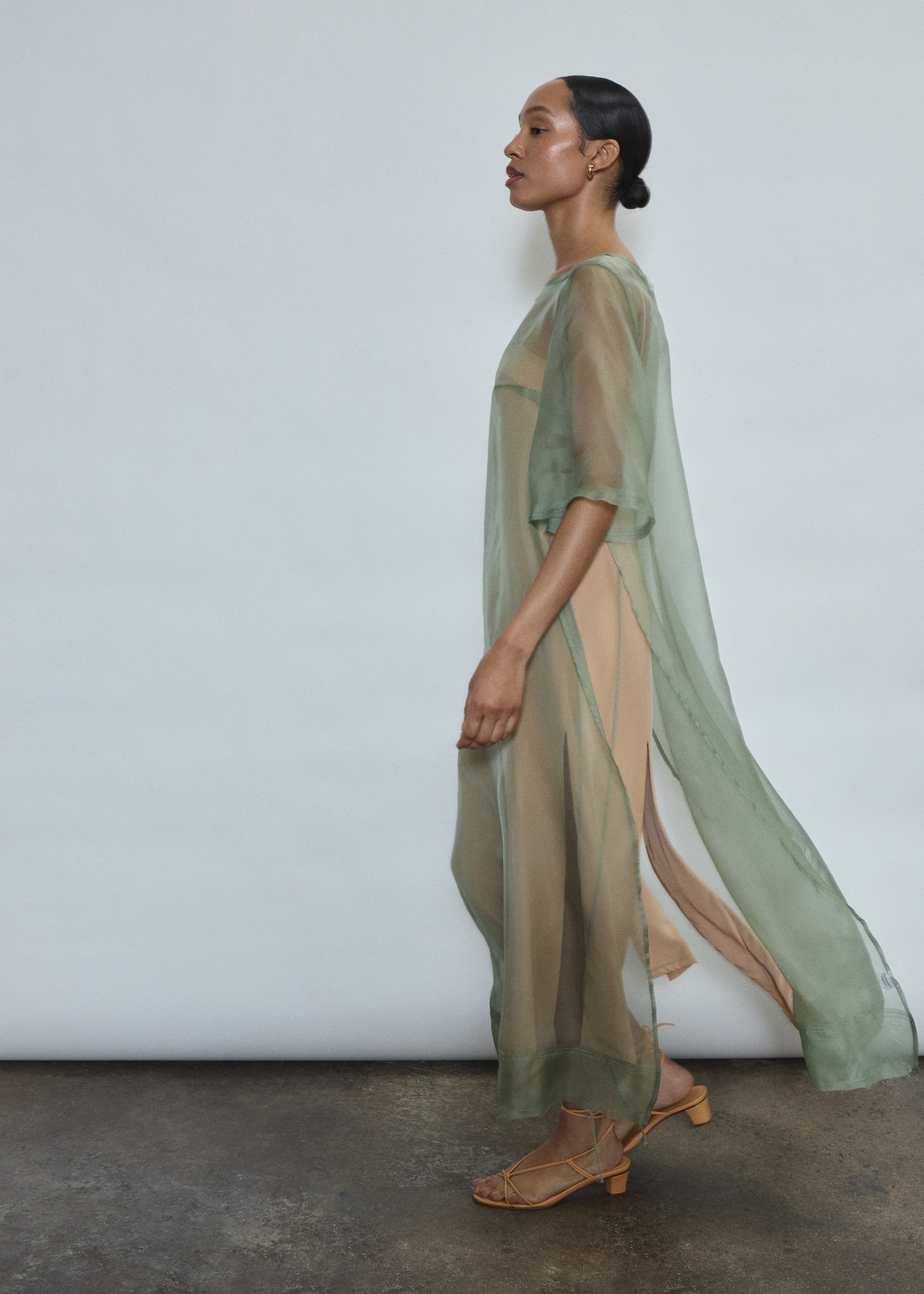 Left profile of jade silk organza Thea Sheath Dress. Straight-cut minimalist silhouette, cool to the touch and luminous in motion. Designed in San Francisco.