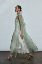 Left profile of jade silk organza Thea Sheath Dress. Straight-cut minimalist silhouette, cool to the touch and luminous in motion. Designed in San Francisco.
