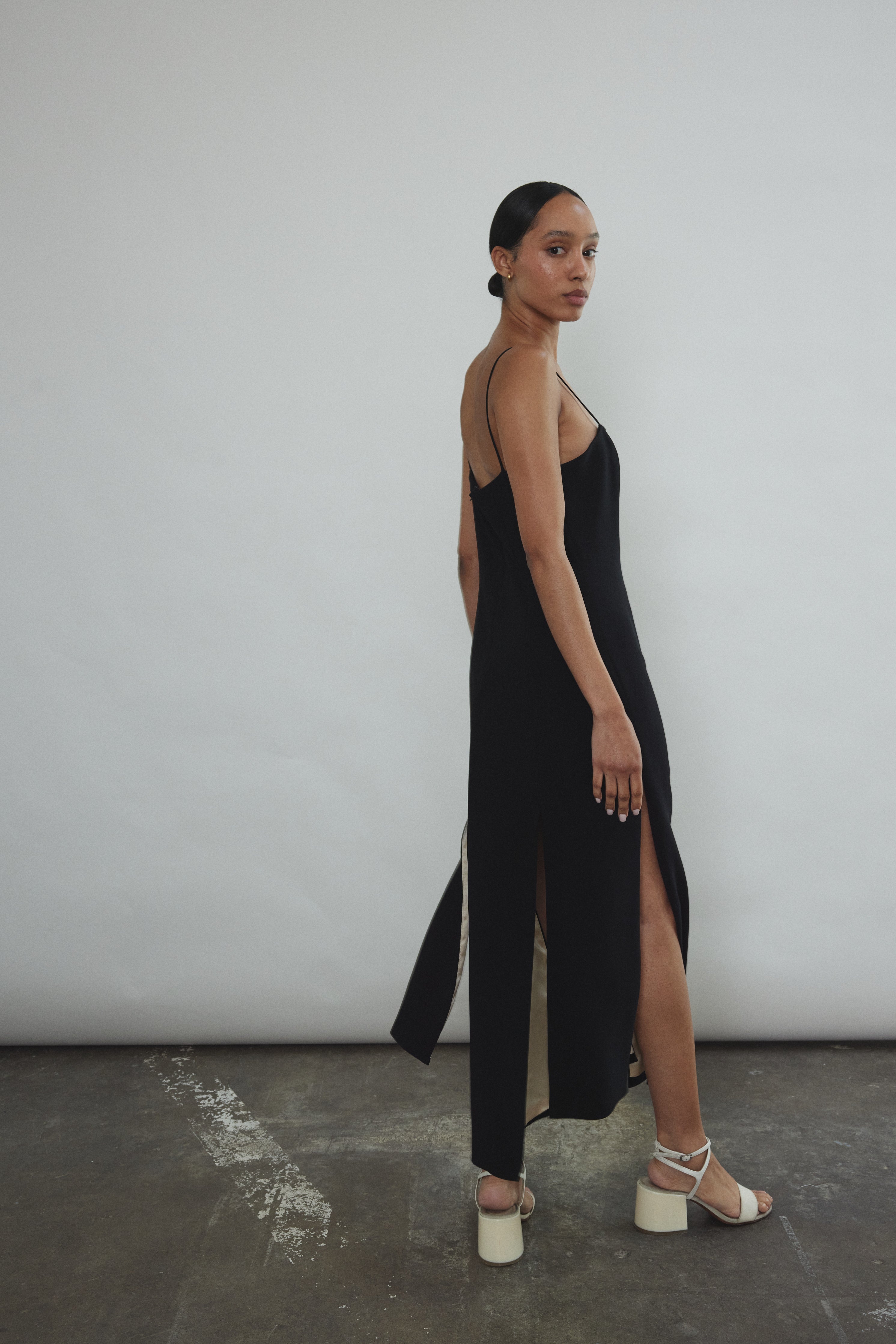 Editorial portrait of a model in the black crepe Kamperett Theodora Dress.