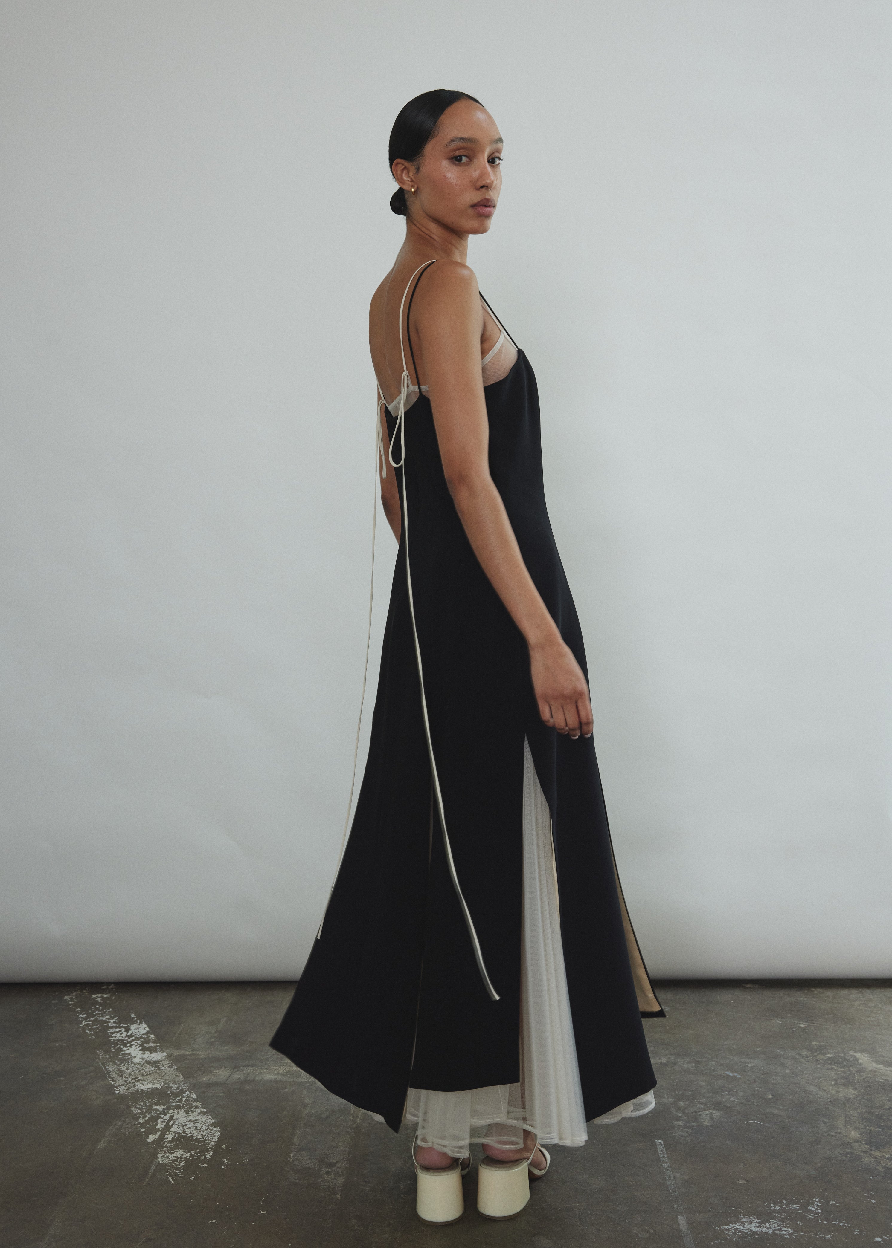 Detail of the multi-slit hemline on the black crepe Kamperett Theodora Dress.