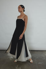 Side view of the black crepe Kamperett Theodora Dress showing the multi-slit hemline.
