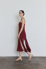 Detail of the bordeaux silk Kamperett Theodora Dress showing the multi-slit hem construction.