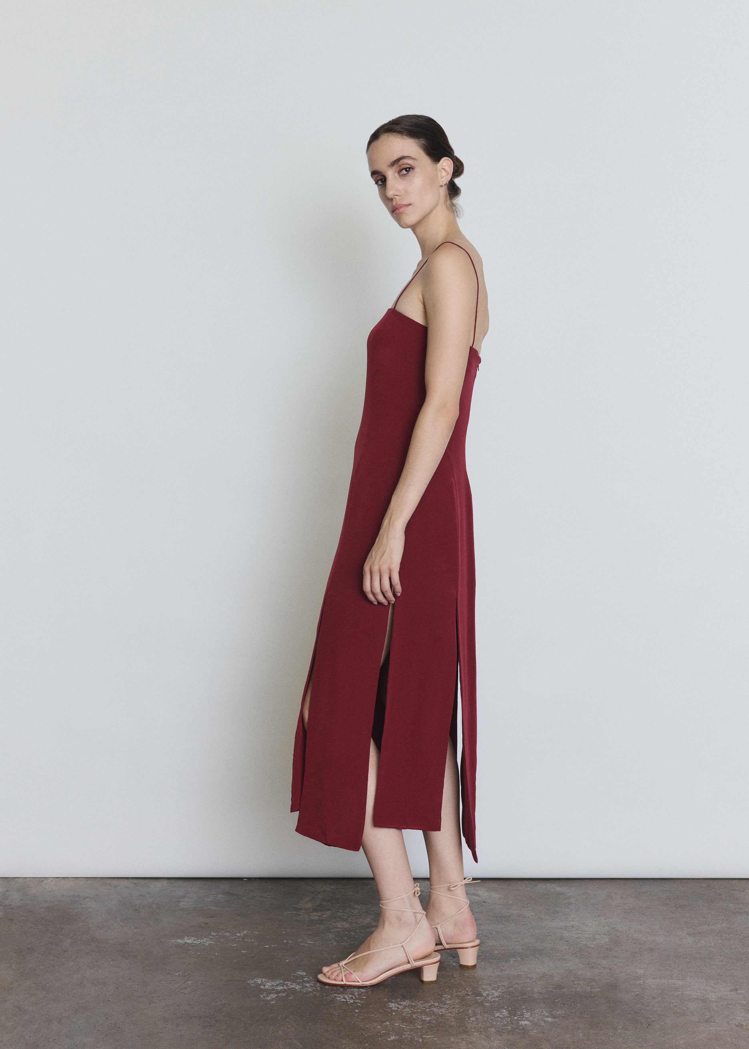 Side view of the bordeaux silk Kamperett Theodora Dress showing the straight-cut silhouette.