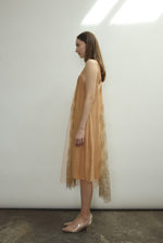 Left profile of Kamperett Thistle Lace Shift in persimmon — effortless A-line silhouette in delicate French lace tulle, sleeveless, minimalist occasion dress.