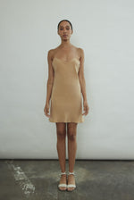 Front view of a model wearing the buff silk Kamperett V-Neck Mini Slip, a bias-cut mini with V-neckline.
