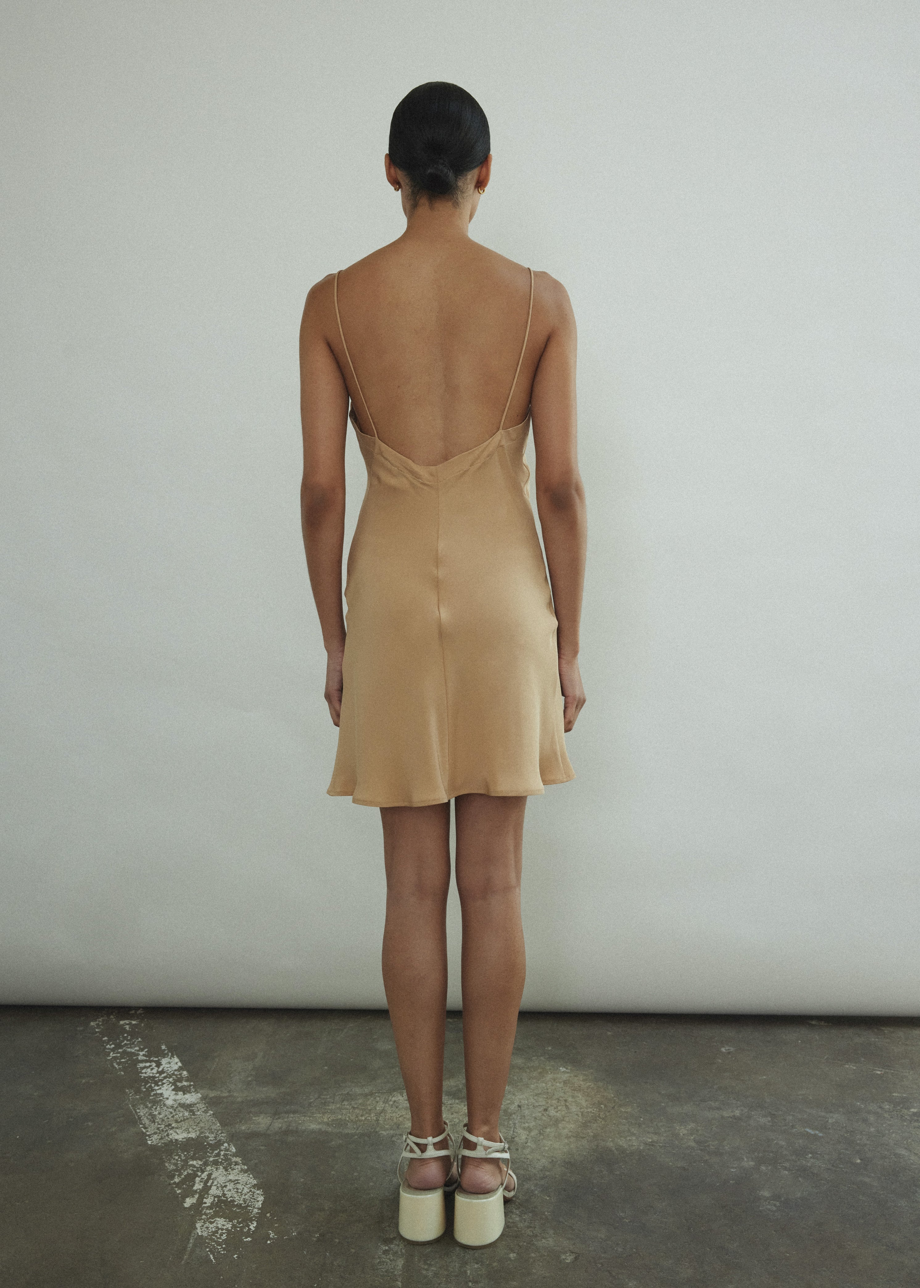 Side view of the buff silk Kamperett V-Neck Mini Slip with V back.
