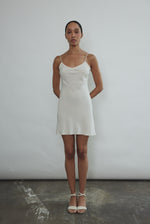 Front view of a bride wearing the ivory silk Kamperett V-Neck Mini Slip, a bias-cut mini with V-neckline.