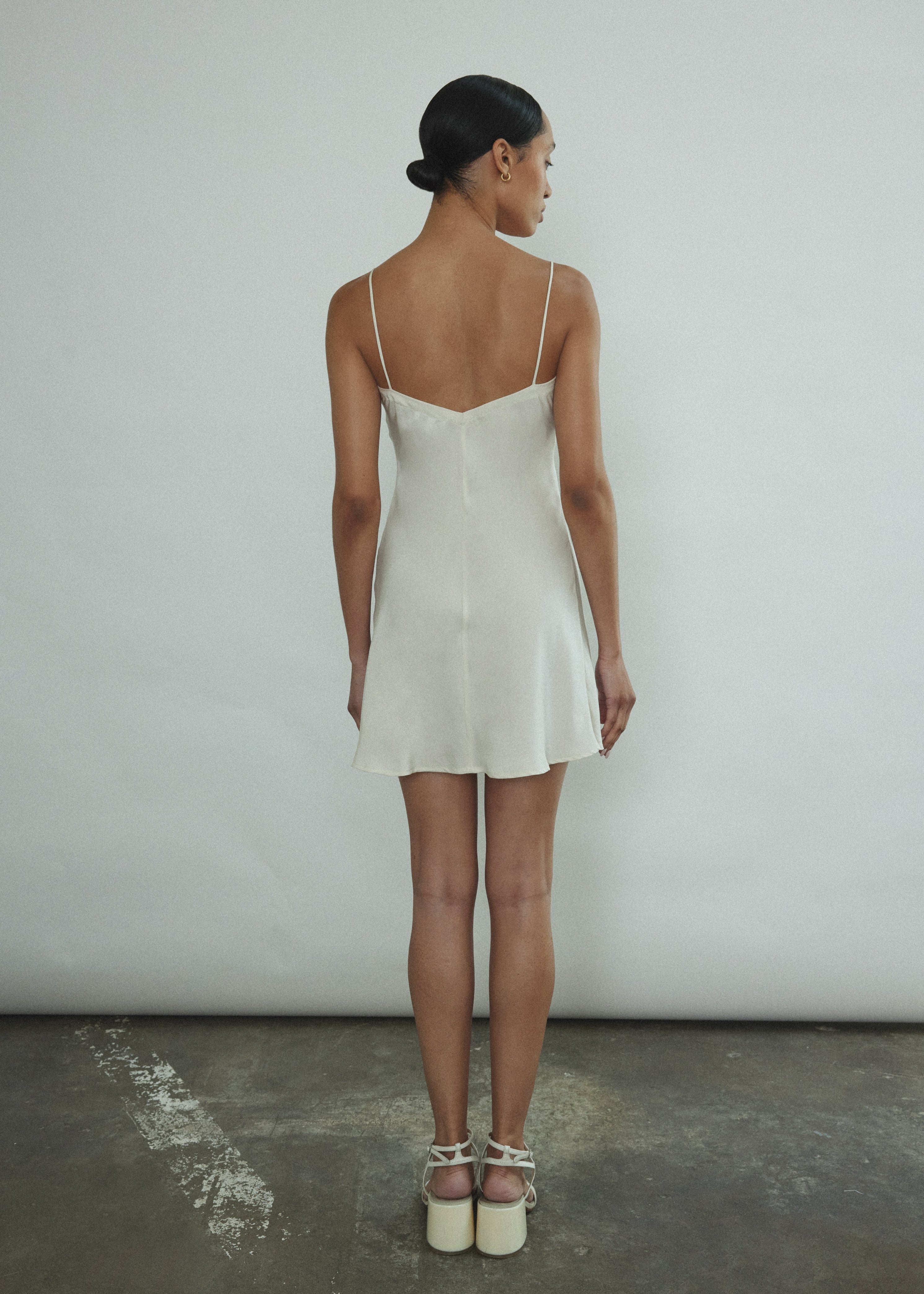 Side view of the ivory silk Kamperett V-Neck Mini Slip with V back.