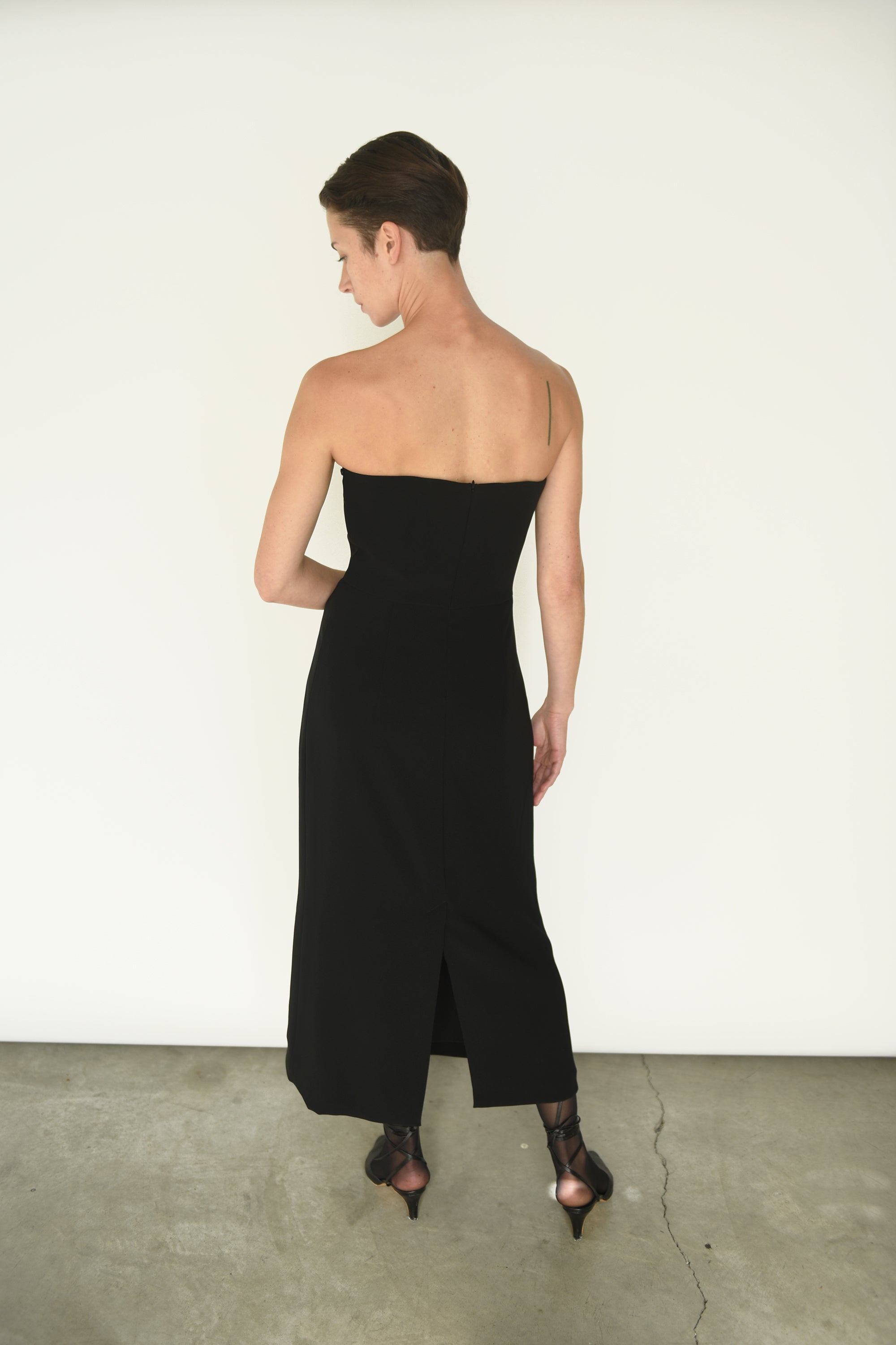 Back view of the black crepe Kamperett Verona Midi Dress with zipper closure at center back.