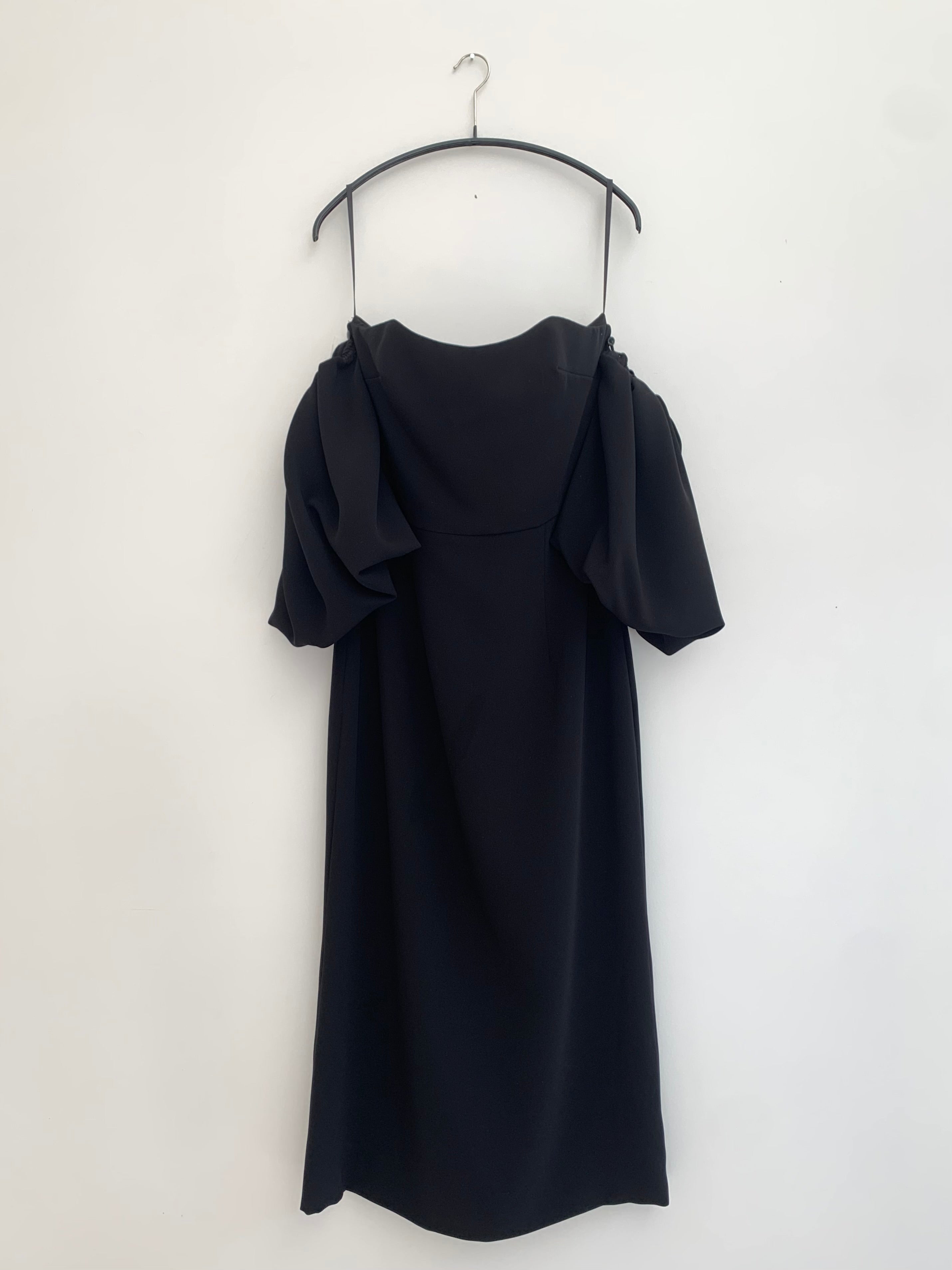 Editorial image of the black crepe Kamperett Verona Midi Dress, a modern occasion dress.