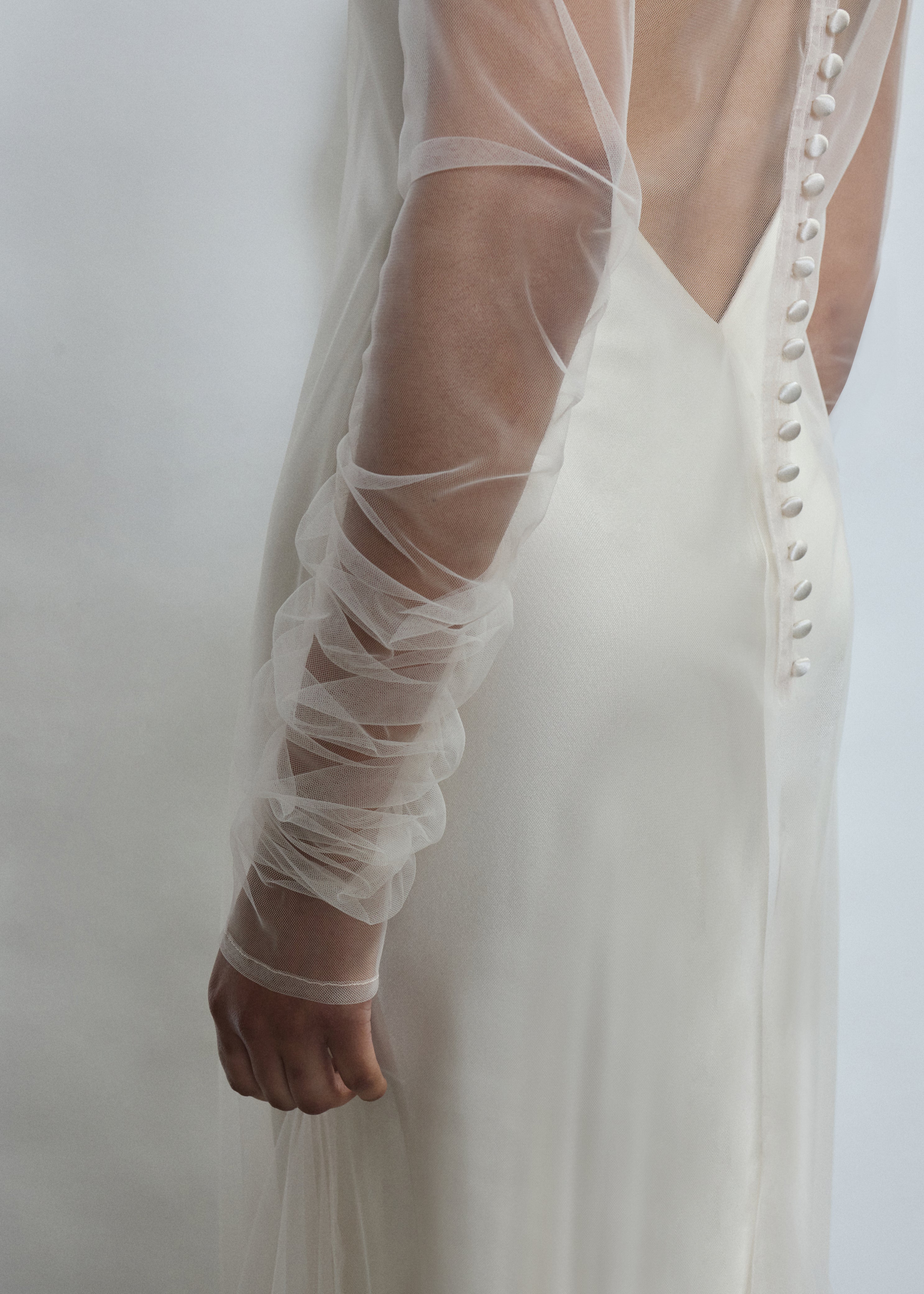 Close-up of delicate gathering on sheer ivory tulle sleeves of the Violette dress. Timeless luxury finish, designed and crafted in California.