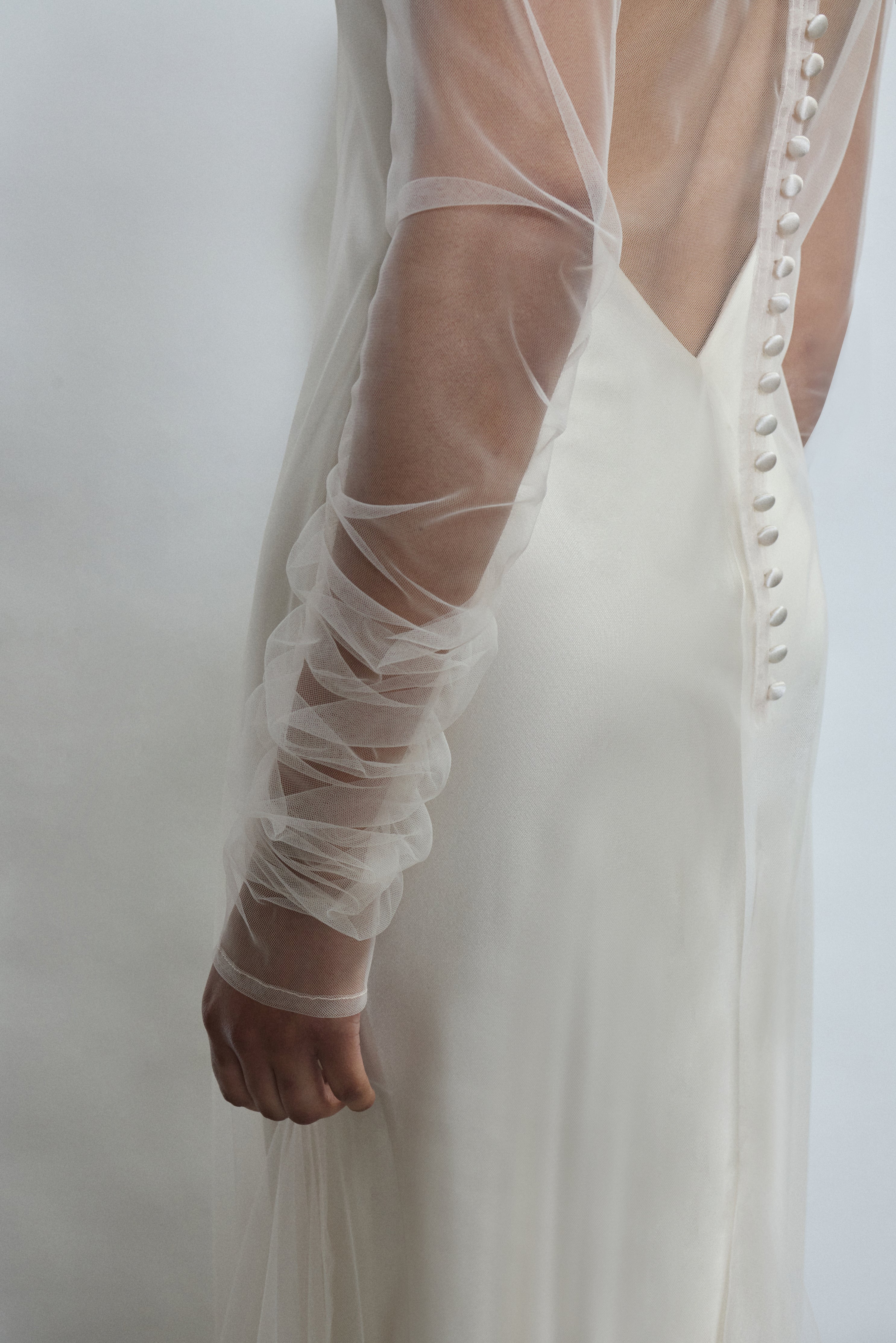 Close-up of delicate gathering on sheer ivory tulle sleeves of the Violette dress. Timeless luxury finish, designed and crafted in California.
