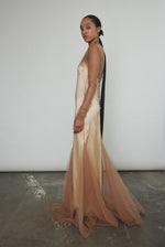 Left profile of Kamperett Violette Tulle Sheath in mocha — sleek sheath silhouette transitions into a sweeping sculptural hem, sheer tulle layer throughout.
