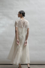 Model wearing the voluminous Kamperett Anemoia Midi dress in Ivory silk organza, highlighting the architectural French seams and graceful midi-length silhouette.