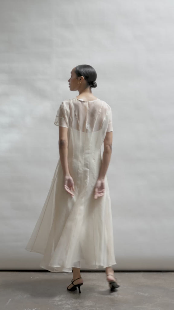 Model wearing the voluminous Kamperett Anemoia Midi dress in Ivory silk organza, highlighting the architectural French seams and graceful midi-length silhouette.