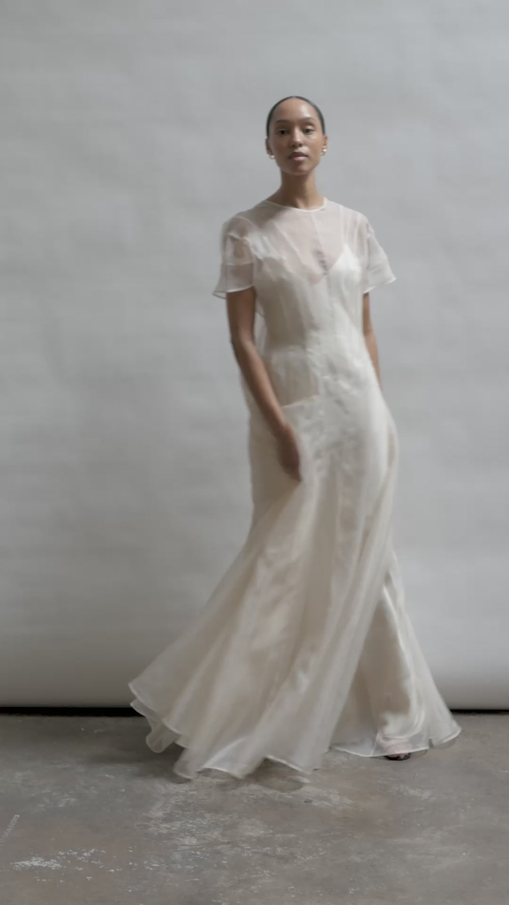 Model wearing the voluminous Kamperett Anemoia Gown in Ivory silk organza, featuring architectural French seams and a graceful floor-length silhouette.