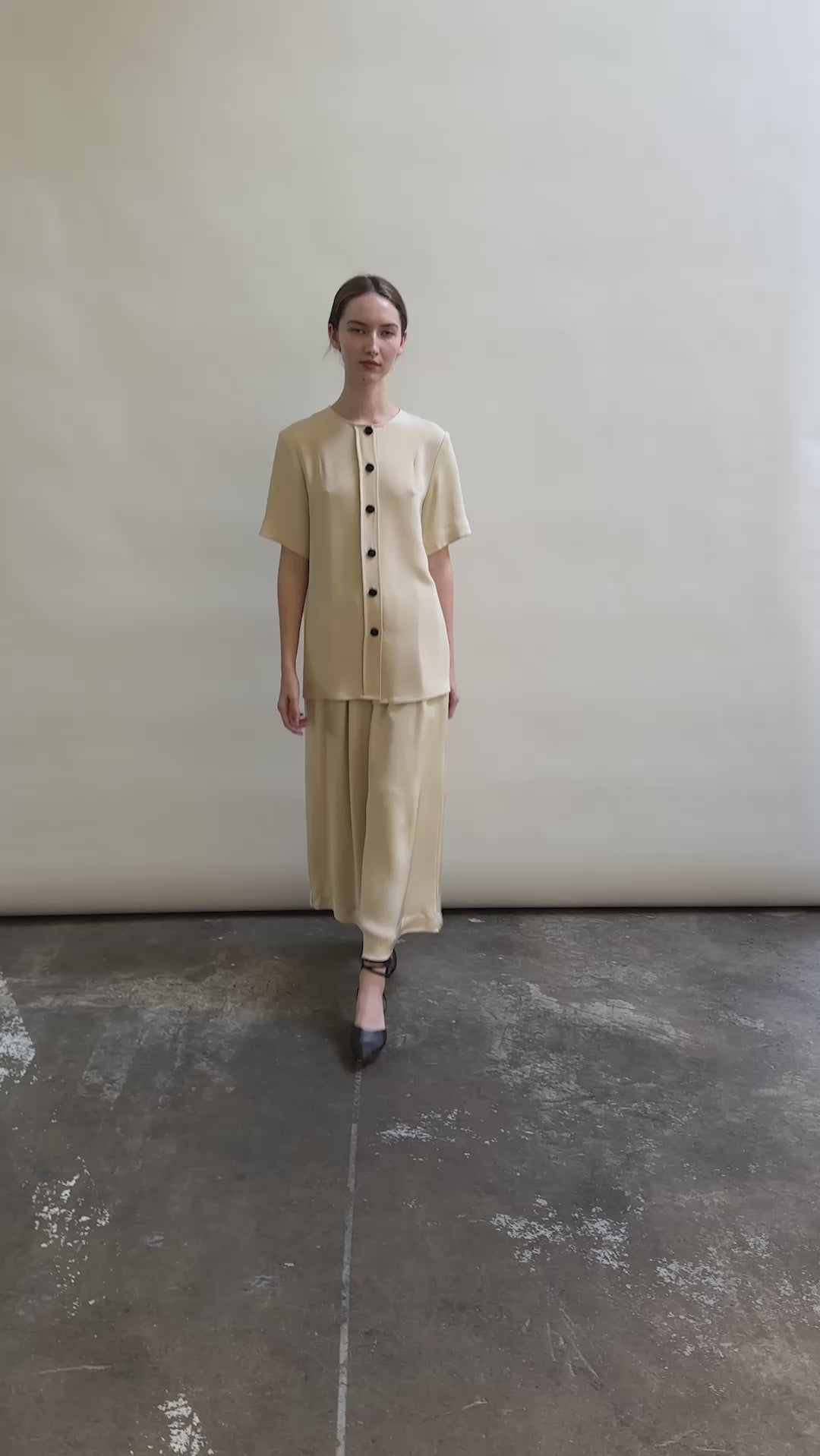 Model wearing the Kamperett Alix Pant in Beige silk crepe, featuring a high-waisted wide-leg fit and a sophisticated fluid drape.