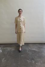Model wearing the Kamperett Alix Pant in Beige silk crepe, featuring a high-waisted wide-leg fit and a sophisticated fluid drape.