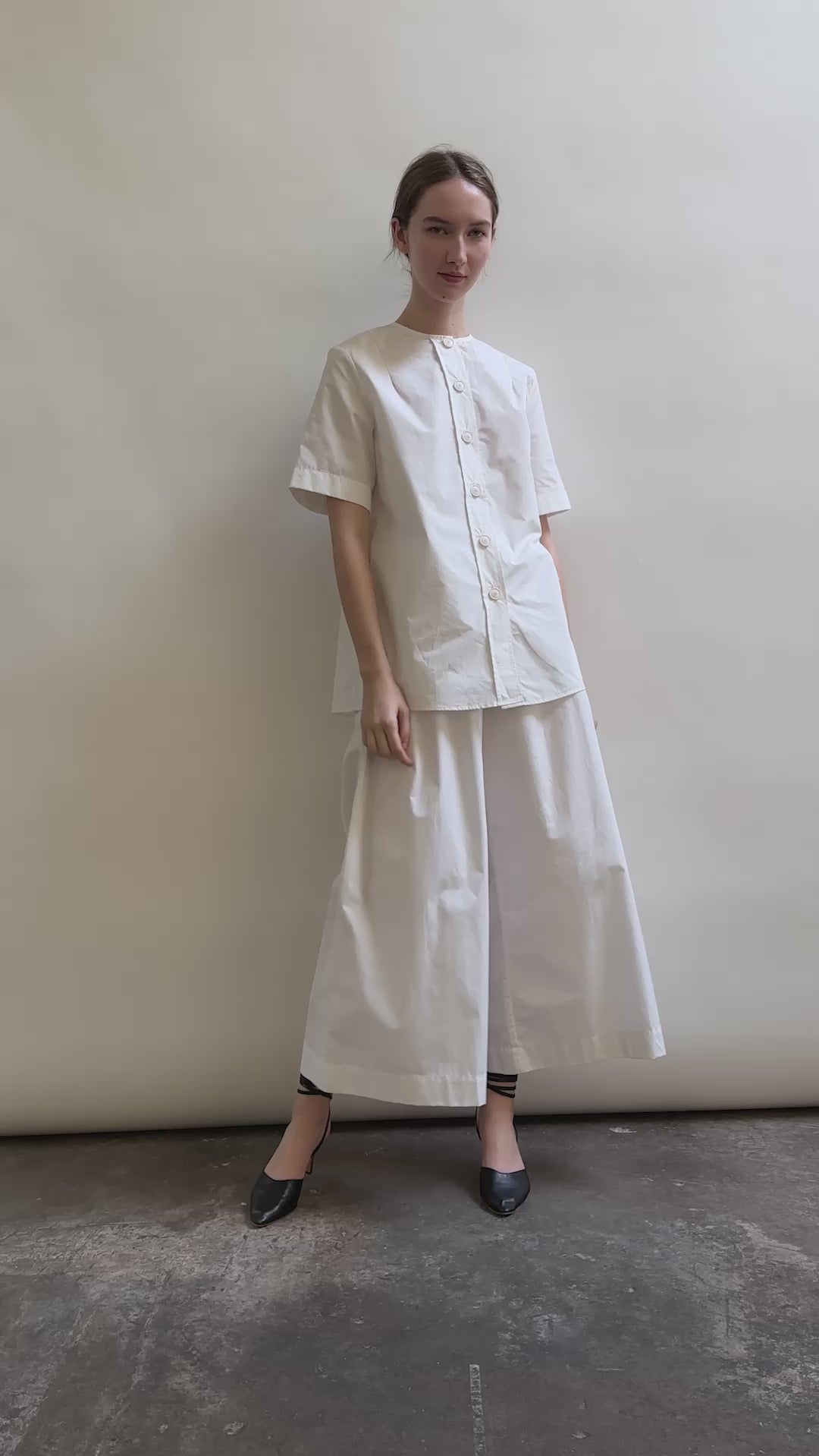 Model wearing the Kamperett Alix Pant in White, featuring a high-waisted wide-leg silhouette in crisp Japanese cotton lawn with deep side pockets.