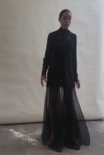 Kamperett Isabella Tunic in black lace mid-movement, silk cord ties flowing at sides, eyelash hem lifting softly, capturing the fluid drape of unlined French lace fabric.
