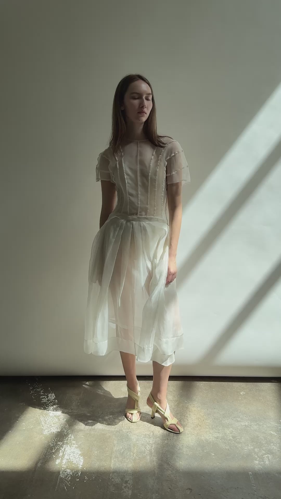 Model wearing the Kamperett Anemoia Blouse in Ivory silk organza, highlighting the voluminous sculptural sleeves and elegant mock neck silhouette.