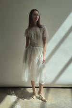 Model wearing the Kamperett Anemoia Blouse in Ivory silk organza, highlighting the voluminous sculptural sleeves and elegant mock neck silhouette.