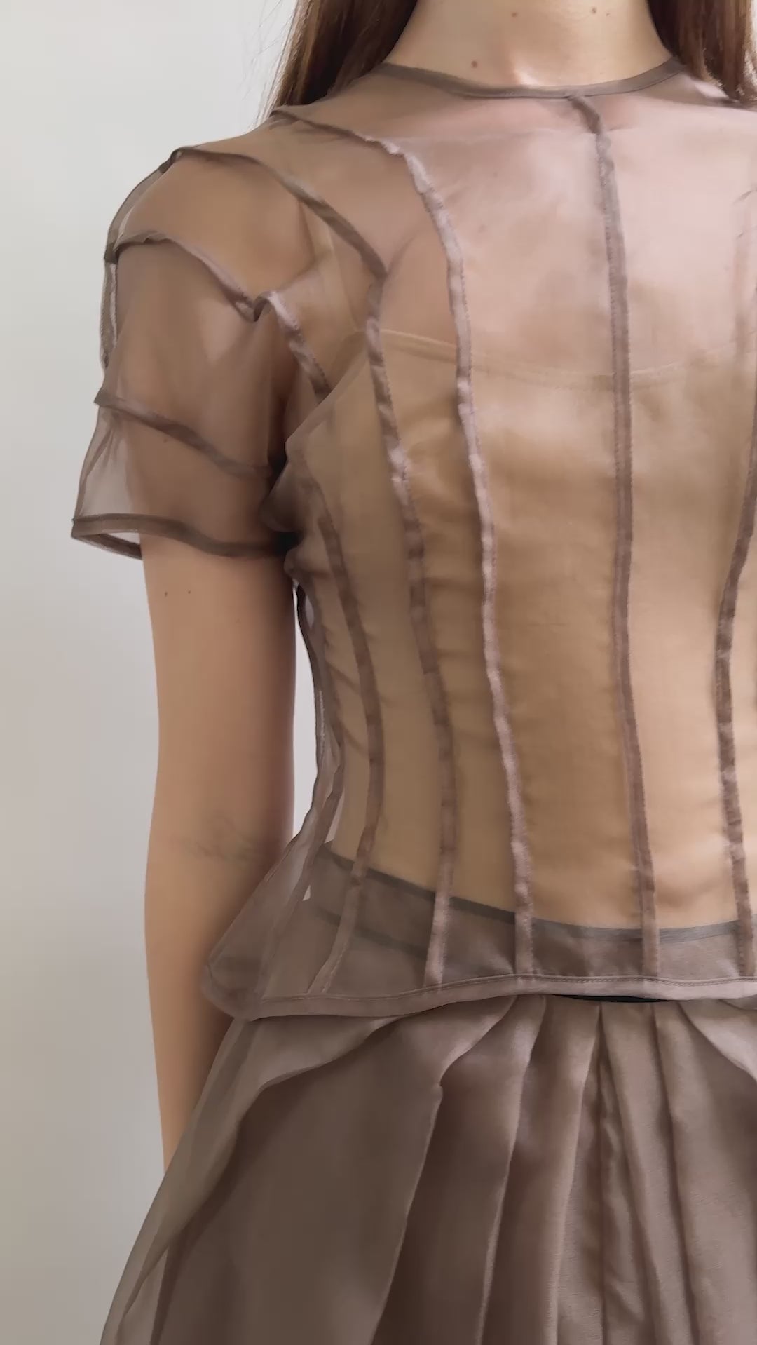 Model wearing the Kamperett Anemoia Blouse in Mushroom silk organza, highlighting the voluminous sculptural sleeves and elegant mock neck silhouette.