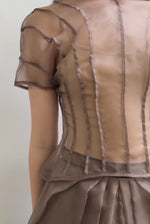 Model wearing the Kamperett Anemoia Blouse in Mushroom silk organza, highlighting the voluminous sculptural sleeves and elegant mock neck silhouette.