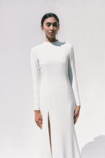 Full-length view of the Kamperett Arc Gown in Ivory silk crepe, featuring a minimalist mock neck, long tapered sleeves, and a sculptural side leg slit.