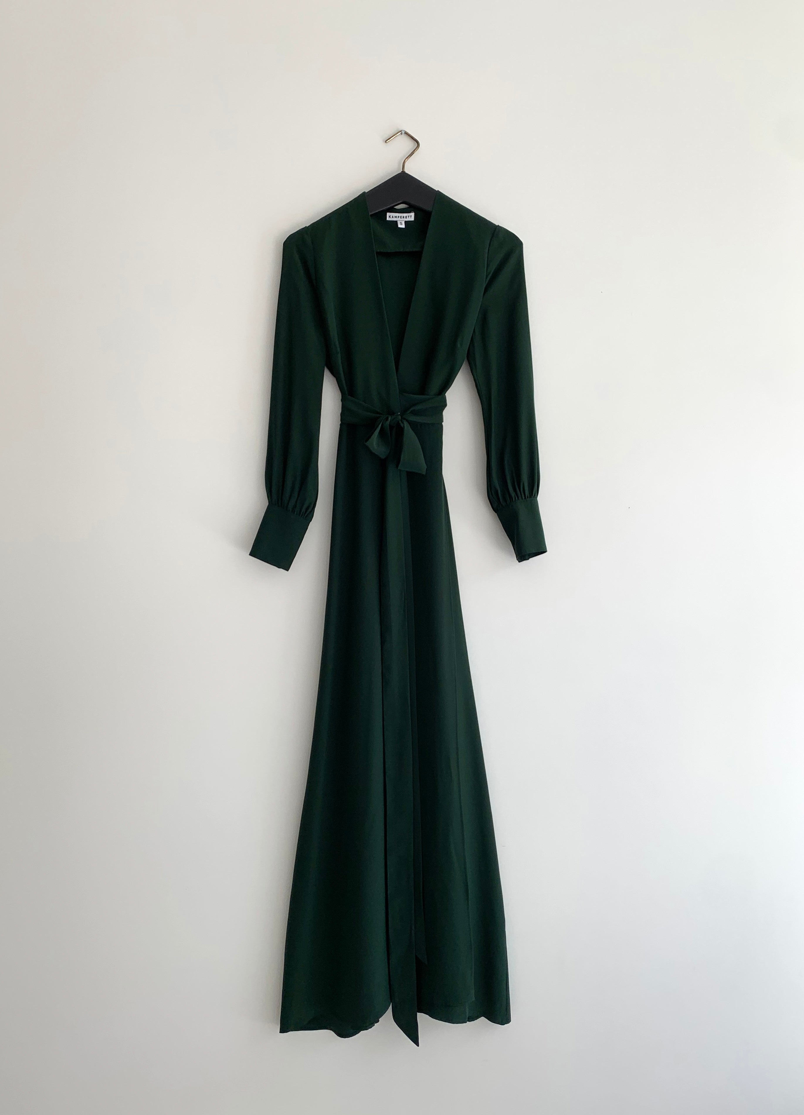 Side view of the dark green silk charmeuse Kamperett Adelaide Gown showing the full sleeves and self-belt at the waist.