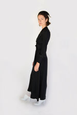 Angled view of the black matte silk charmeuse Kamperett Adelaide Midi Dress with full sleeves and self-belt.
