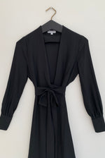 Alternate editorial image of the black matte silk charmeuse Kamperett Adelaide Midi Dress, a wrap silhouette.