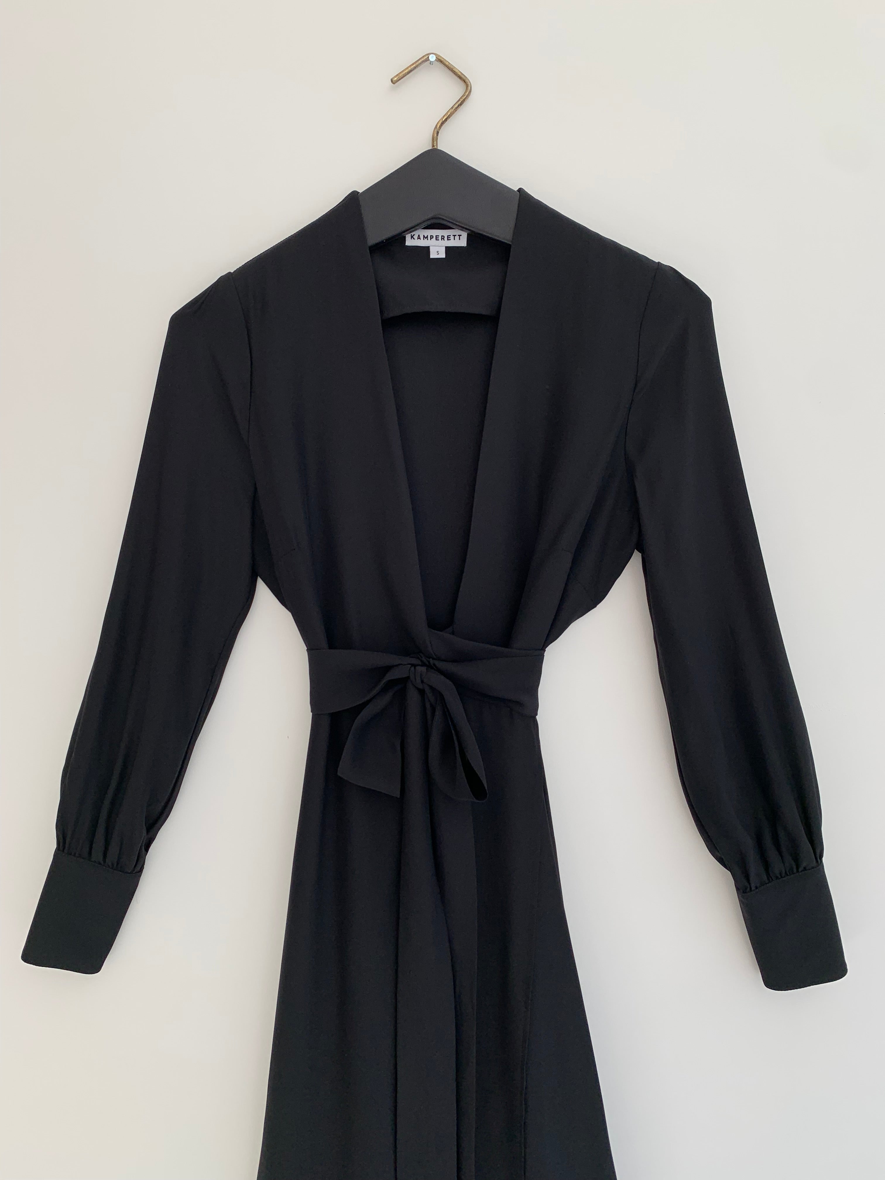 Alternate editorial image of the black matte silk charmeuse Kamperett Adelaide Midi Dress, a wrap silhouette.