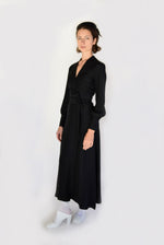 Front view of a model wearing the black matte silk charmeuse Kamperett Adelaide Midi Dress, a wrap dress with plunging neckline and full sleeves.
