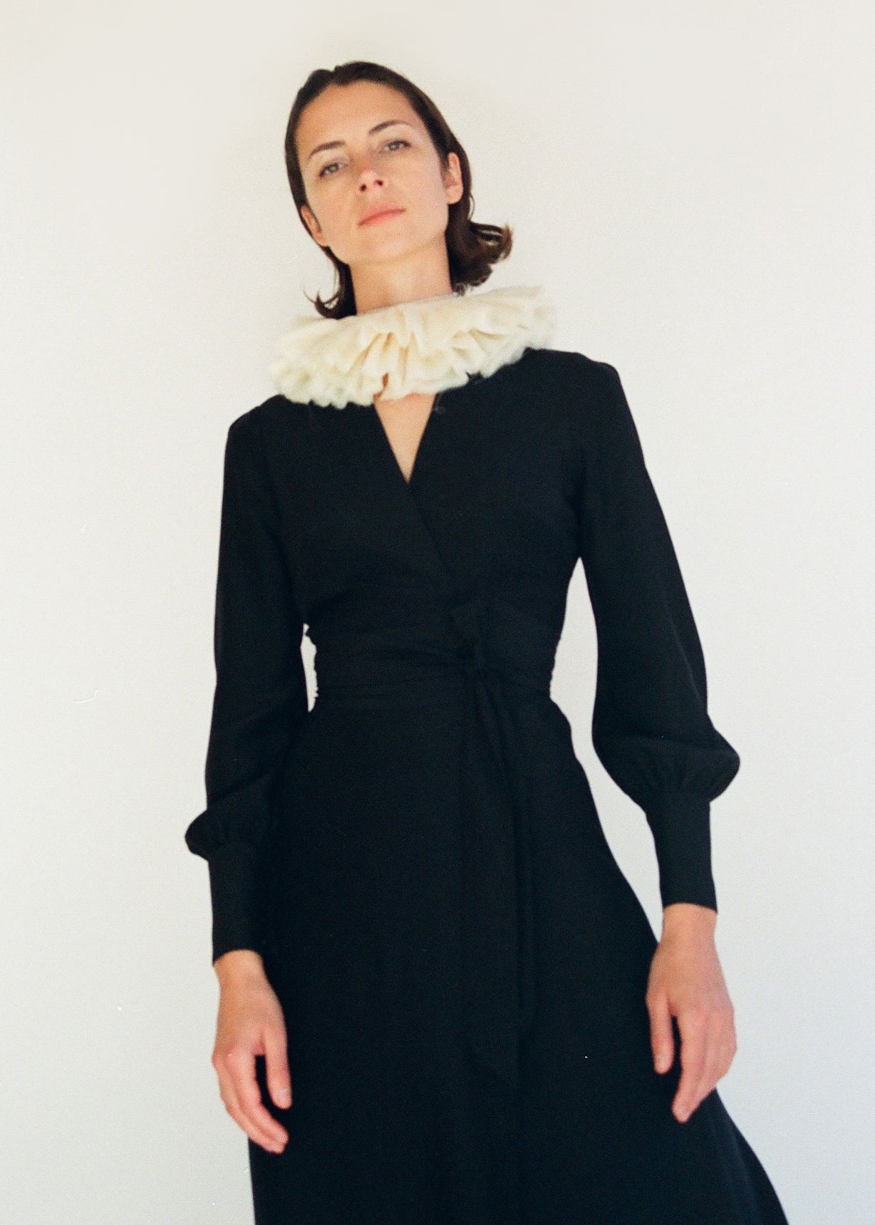 Detail of the wrap neckline on the black matte silk charmeuse Kamperett Adelaide Midi Dress.