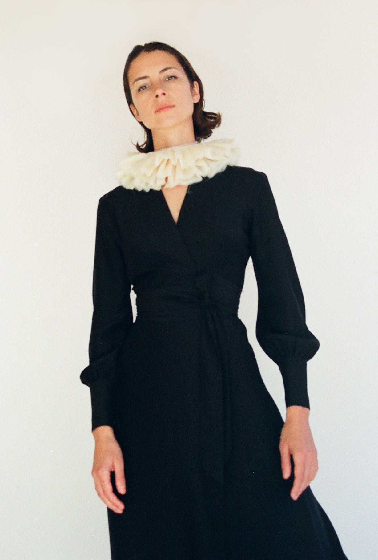 Detail of the wrap neckline on the black matte silk charmeuse Kamperett Adelaide Midi Dress.