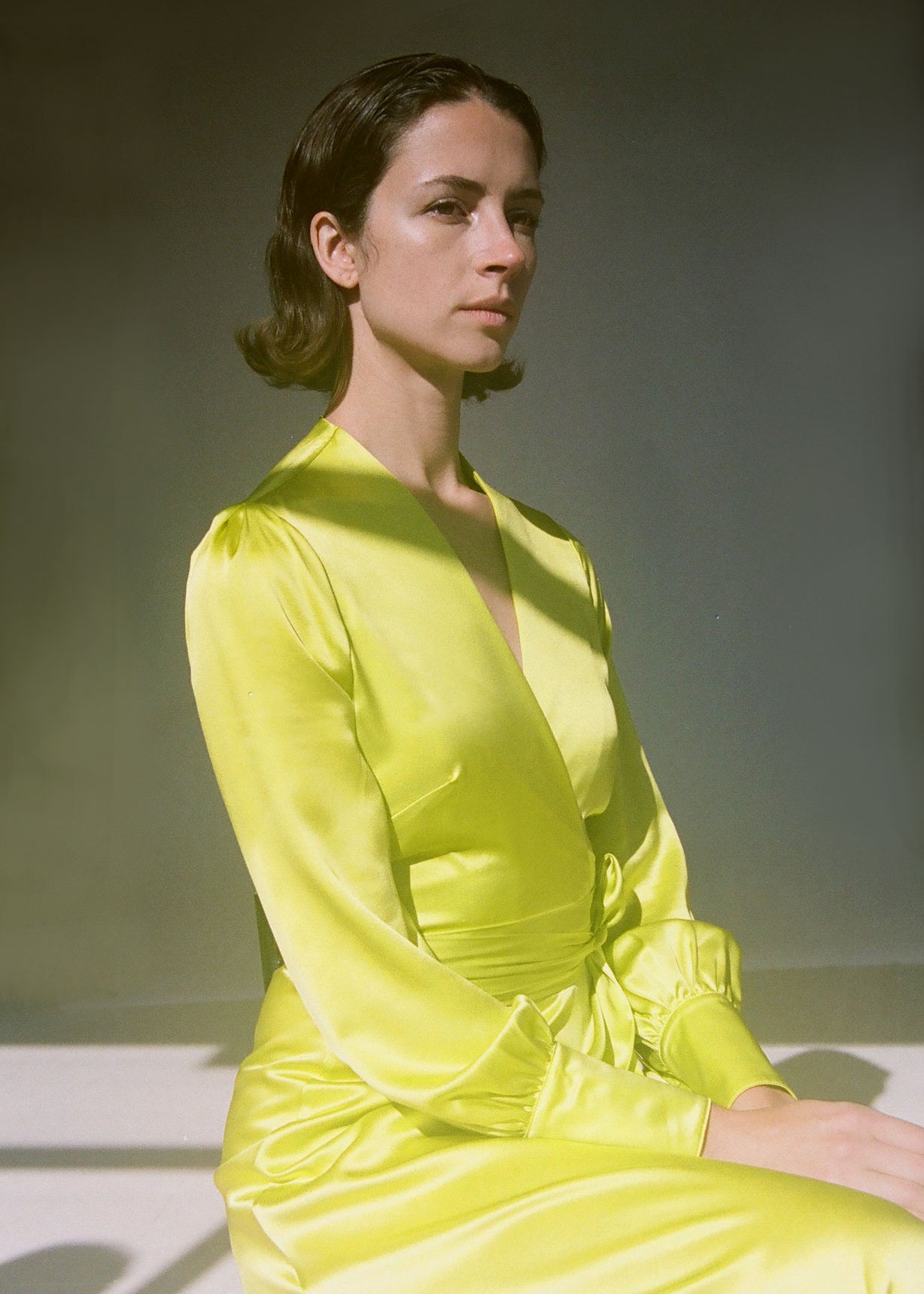 Editorial image of the chartreuse satin silk charmeuse Kamperett Adelaide Midi Dress.